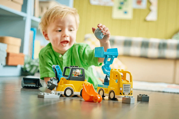 Otrok upravlja z bagerjem DUPLO